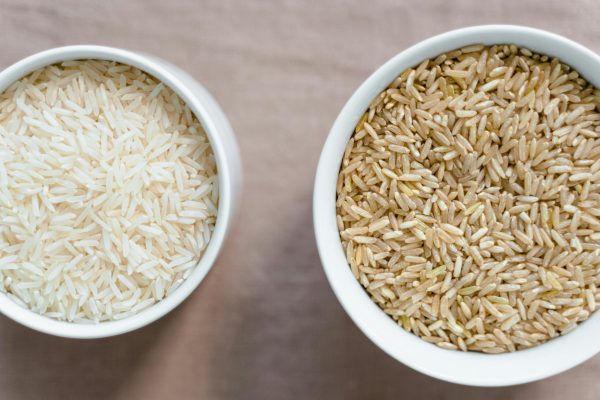pexels-photo-8108116-8108116 Top-down view of uncooked white and brown rice in bowls, showcasing healthy dietary choices.